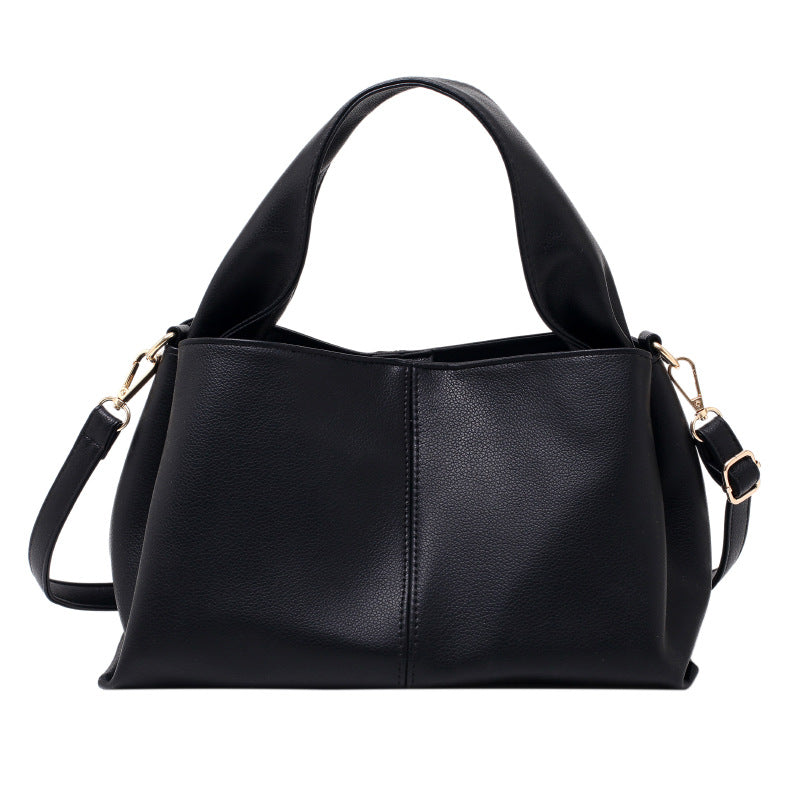 Medium Everyday Shoulder Bag in sleek black faux leather with structured silhouette and adjustable strap.